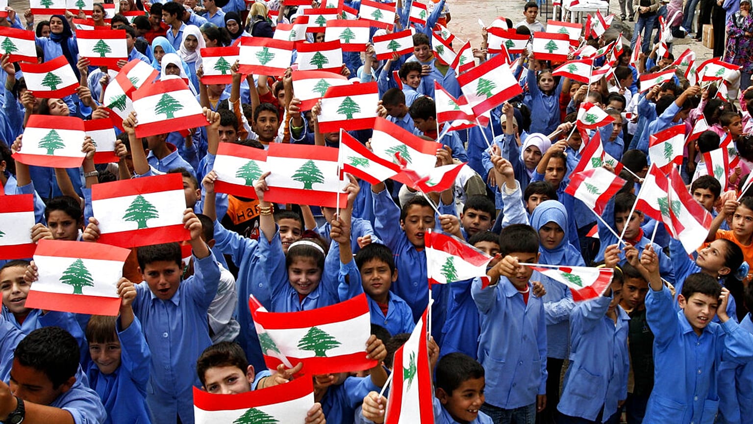 طلاب مدرسة في جنوب لبنان يلوحون بالعلم اللبناني