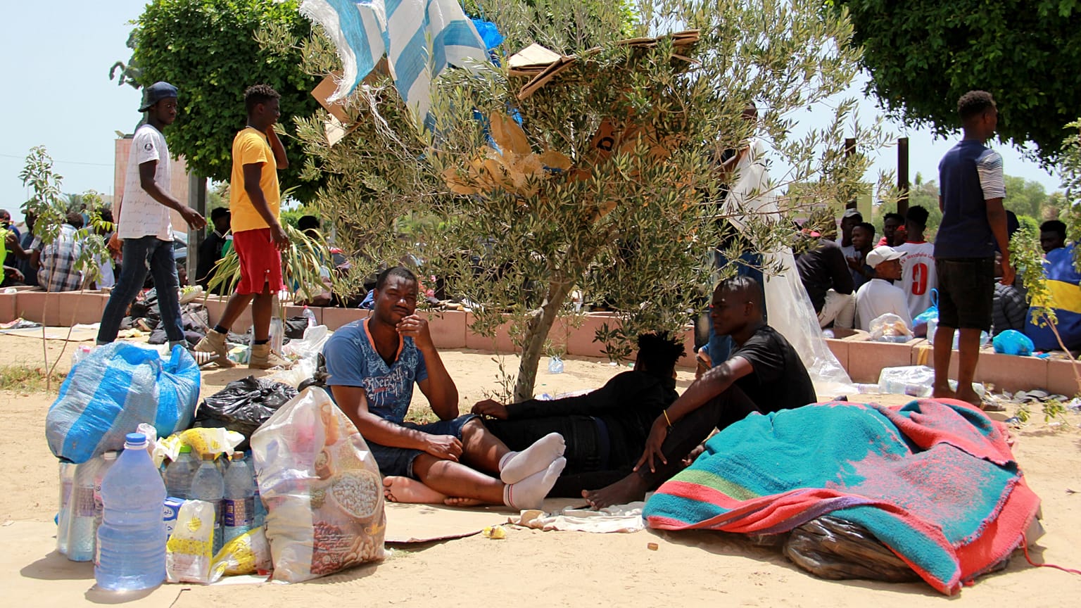 I migranti riposano durante un raduno a Sfax, 7 luglio 2023