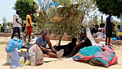 I migranti riposano durante un raduno a Sfax, 7 luglio 2023
