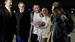 Ksenia Karelina y su prometido, el boxeador profesional Chris van Heerden, conversan en la pista a su llegada el jueves 10 de abril de 2025 a la Base Conjunta Andrews, Maryland (AP Photo/Alex Br