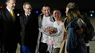Ksenia Karelina y su prometido, el boxeador profesional Chris van Heerden, conversan en la pista a su llegada el jueves 10 de abril de 2025 a la Base Conjunta Andrews, Maryland (AP Photo/Alex Br