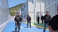I poliziotti sorvegliano il centro di accoglienza per migranti, presso il porto di Shenjin, nel nord-ovest dell'Albania, mercoledì 5 giugno 2024.