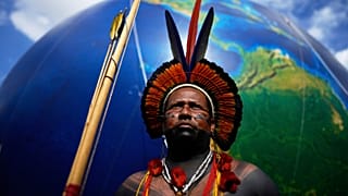 Un homme autochtone se tient à côté d'un grand ballon en terre lors de la marche baptisée : "Nous sommes la réponse" à Brasilia, Brésil, jeudi 10 avril 2025