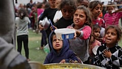 Palästinensische Kinder erhalten gespendete Lebensmittel in einem Verteilungszentrum in Nuseirat, 11. April 2025