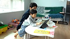 Father Kim Jungu and and his son, Dohun, playing and learning through an AI.
