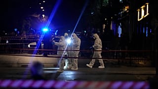 Des officiers de la police scientifique vérifient la zone après l'explosion d'une bombe devant les bureaux de la compagnie Hellenic Train à Athènes, le 11 avril 2025.