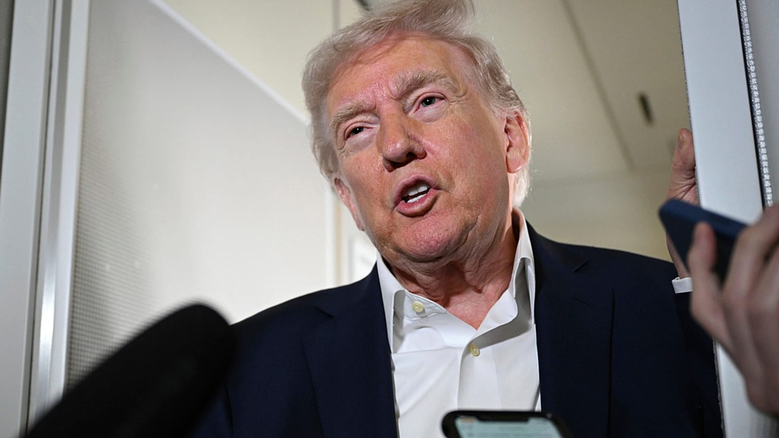 Präsident Donald Trump spricht mit Reportern an Bord der Air Force One auf dem Weg zum Palm Beach, Florida, Freitag, 11. April 2025. 
