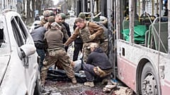 Ukrainische Soldaten tragen eine Leiche aus einem Trolleybus nach einem russischen Raketenangriff auf Sumy, Ukraine, Sonntag, 13. April 2025