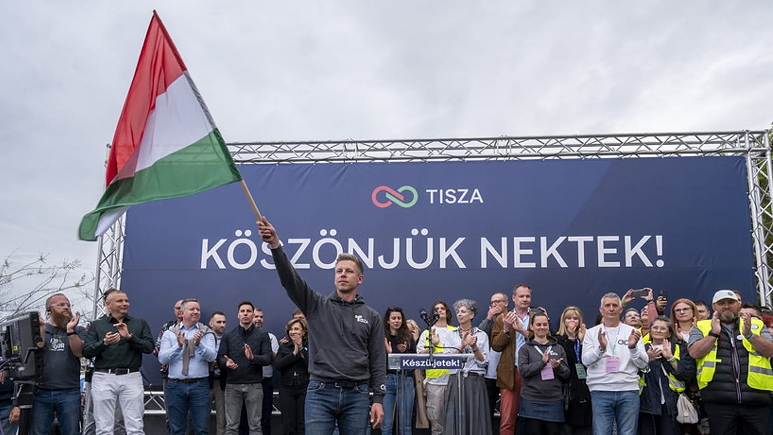 Il leader dell'opposizione ungherese del partito Tisza, Peter Magyar, sventola la bandiera ungherese durante un comizio a Budapest, Ungheria, domenica 13 aprile 2025.