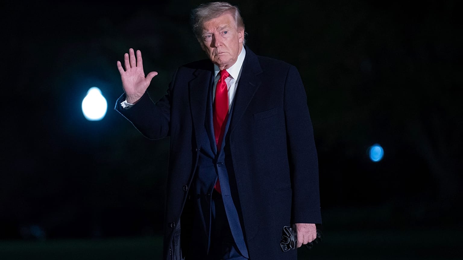 Başkan Donald Trump, 13 Nisan 2025 Pazar günü Washington'daki Beyaz Saray'ın Güney Bahçesi'nde yürürken gazetecilere el hareketi yapıyor. 