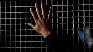 A Syrian man in Cyprus waves to his relatives as they sit inside a bus at the Pournara migrant reception centre outside Nicosia, 24 January, 2024