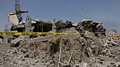 Un oficial de seguridad Houthi inspecciona los escombros de un edificio destruido al parecer alcanzado por ataques aéreos estadounidenses en Sanaa, Yemen, el lunes 7 de abril 