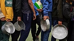 Bambini palestinesi in fila in attesa di cibo donato in un centro di distribuzione a Nuseirat, Striscia di Gaza, 11 aprile 2025
