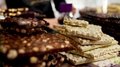 FILE: Chocolate bark is on display behind a glass counter of a shop in Bruges, 6 February 2025