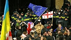 Αστυνομικοί μπλοκάρουν διαδηλωτές που κυματίζουν σημαίες Γεωργίας και ΕΕ κατά τη διάρκεια συγκέντρωσης στην Τιφλίδα