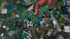 Trabalhador recolhe placas de telemóveis para colocá-las num saco para a reciclagem perto de Nairobi, no Quénia