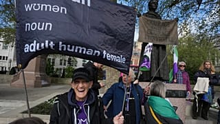 Attiviste per i diritti delle donne tengono cartelli fuori dalla Corte Suprema per contestare le leggi sul riconoscimento di genere, a Londra, 16 aprile 2025