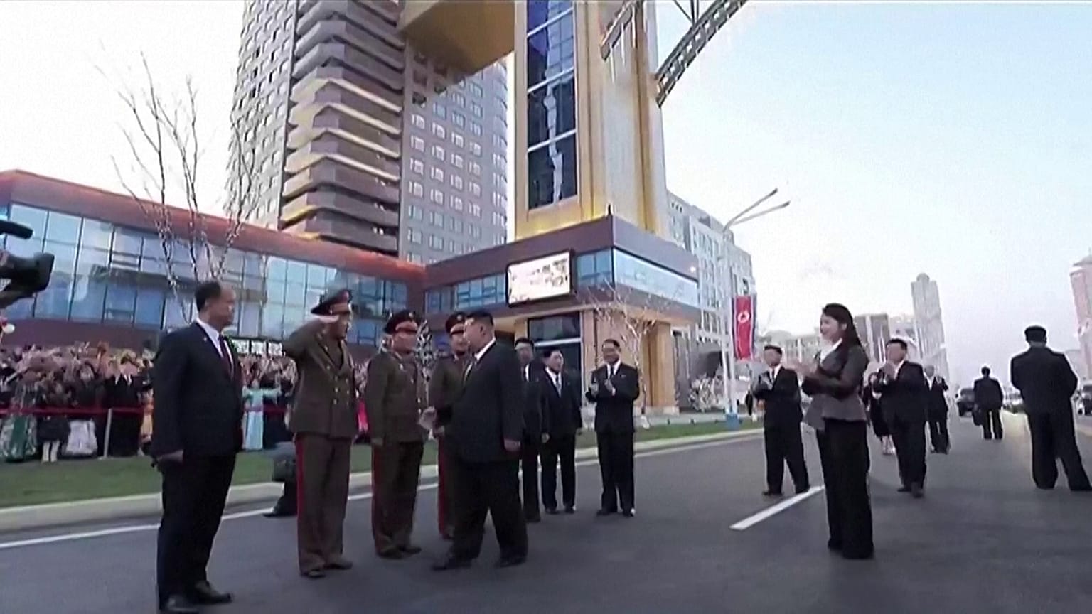  الزعيم الكوري الشمالي كيم جونغ أون يخرج من السيارة ويحيي المسؤولين، وخلفه تقف ابنته كيم جو آي.  15.04.2025