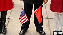 Egy férfi kínai és amerikai zászlóval a kezében Donald Trump 2017-es pekingi látogatásakor
