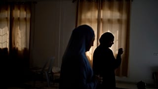 امرأة ووالدتها تقفان داخل قاعة أفراح تُستخدم كمأوى مؤقت للنازحين في شمال الضفة الغربية، الخميس 3 أبريل 2025.
