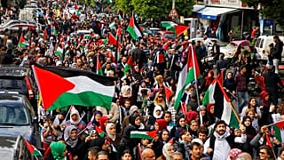 فلسطينيون ولبنانيون يرفعون الأعلام الفلسطينية خلال مسيرة في شوارع بيروت بعد صلاة الجمعة.