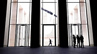 Geschäftsleute stehen vor einem Bürogebäude, das sie gerade verlassen haben, in Frankfurt, Deutschland, Montag, 4. November 2019.
