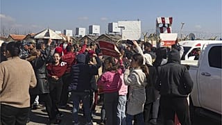 أفراد من العلويين يتجمعون خارج القاعدة الجوية الروسية في حميميم ، بالقرب من اللاذقية في المنطقة الساحلية السورية ، الثلاثاء 11 مارس / آذار 2025 