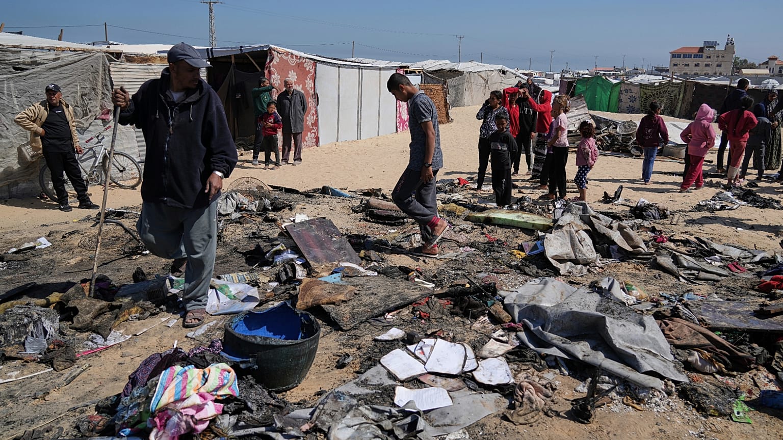 فلسطينيون يتفقدون بقايا خيمة للنازحين أصابتهم غارة جوية إسرائيلية خلال الليل، مما أسفر عن مقتل 10 أفراد من عائلة أبو الروس، في خان يونس، جنوب قطاع غزة