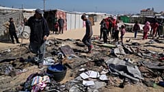 فلسطينيون يتفقدون بقايا خيمة للنازحين أصابتهم غارة جوية إسرائيلية خلال الليل، مما أسفر عن مقتل 10 أفراد من عائلة أبو الروس، في خان يونس، جنوب قطاع غزة