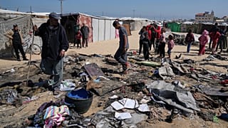 فلسطينيون يتفقدون بقايا خيمة للنازحين أصابتهم غارة جوية إسرائيلية خلال الليل، مما أسفر عن مقتل 10 أفراد من عائلة أبو الروس، في خان يونس، جنوب قطاع غزة
