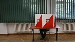 Mężczyzna przygotowuje kartę do głosowania w wyborach parlamentarnych w Warszawie, w niedzielę 15 października 2023 r.