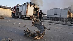 Ein Teil einer Rakete liegt auf dem Boden vor einer durch einen russischen Angriff zerstörten Fabrik in Charkiw, 18. April 2025