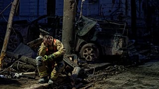 A rescue worker rests near a university building destroyed by a Russian missile strike on Sumy, 13 April, 2025