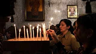 مسيحيون فلسطينيون يشعلون الشموع خلال قداس الجمعة العظيمة في كنيسة القديس برفيريوس الأرثوذكسية اليونانية في مدينة غزة، الجمعة 18 أبريل 2025.