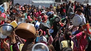 Fotos de cientos de palestinos agolpados ante puestos de comida para recibir ayuda alimentaria
