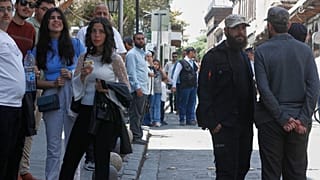 أفراد من قوة الشرطة المشكلة حديثا ، يمين ، يقفون حارسين بينما يشارك المسيحيون السريان الأرثوذكس في احتفالات عيد الفصح في مدينة دمشق القديمة ، سوريا ، الأحد 20 أبريل 2025