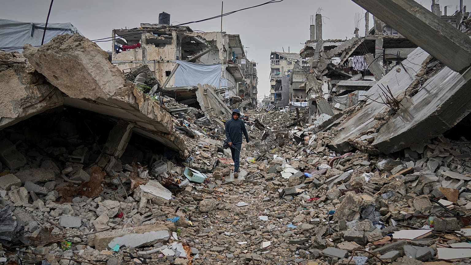 صبي فلسطيني يسير في شارع مغطى بأنقاض المنازل والمباني المدمرة في جباليا، شمال قطاع غزة، الجمعة 7 مارس/آذار 2025