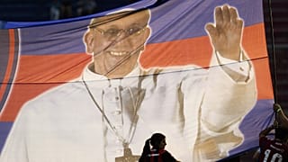 Taraftarlar Buenos Aires'te üzerinde Papa Francis'in fotoğrafı ve San Lorenzo de Almagro futbol kulübünün renkleri bulunan bir pankart tutuyor, 31 Mart 2013