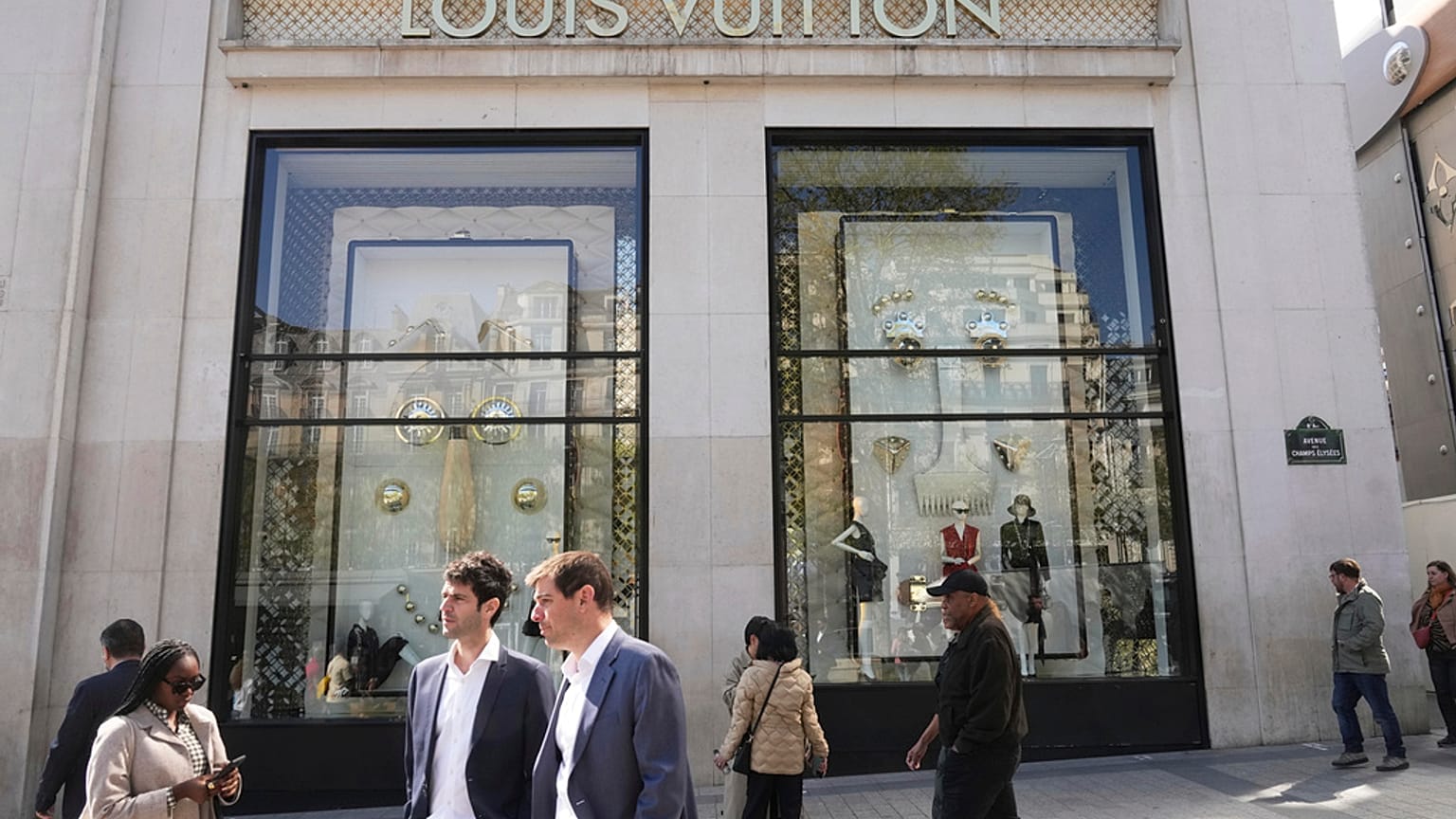 People walk by the Louis Vuitton flagship store Wednesday, April 9, 2025 in Paris. 