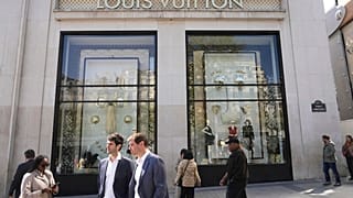 People walk by the Louis Vuitton flagship store Wednesday, April 9, 2025 in Paris. 