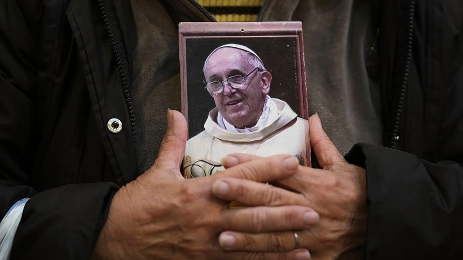 Um fiel segura um retrato do falecido Papa Francisco na Basílica de San José de Flores, onde ele prestou culto quando era jovem, após o anúncio da sua morte pelo Vaticano