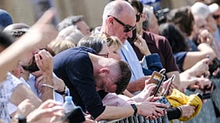 Des fidèles réagissent à l'annonce de la mort du pape François sur la place Saint-Pierre au Vatican, lundi 21 avril 2025.