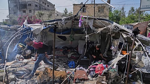 Filistinliler, 21 Nisan 2025 Pazartesi günü Gazze Şehri'nde bir çadıra düzenlenen İsrail ordusu hava saldırısının yerini inceliyor.