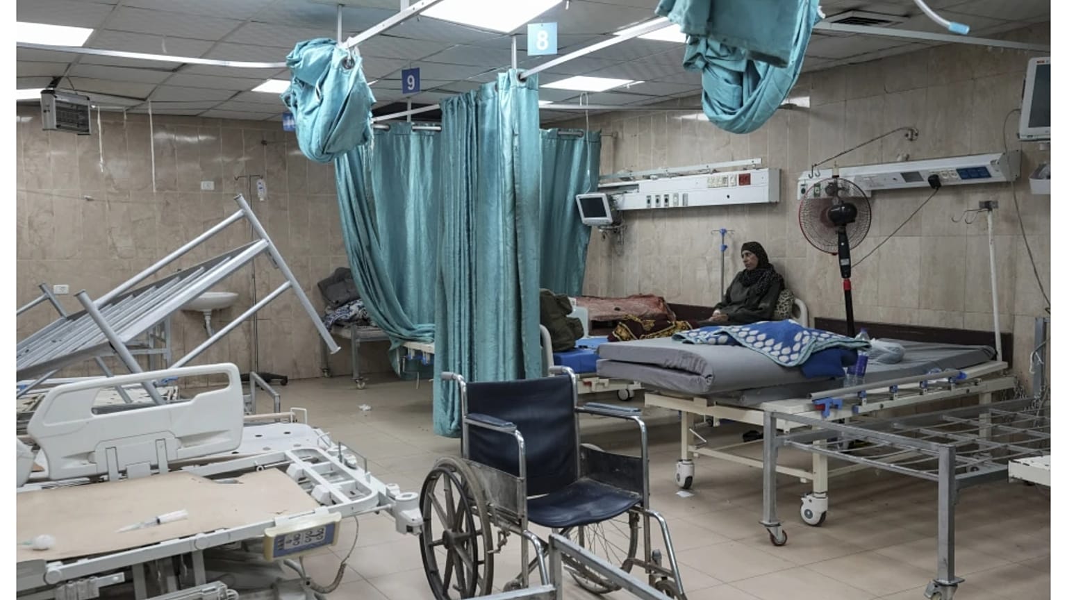 سيدة فلسطينية تجلس على سرير مستشفى في دير البلح بقطاع غزة. 25 أغسطس 2024.