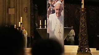 Un poster che raffigura Papa Francesco dopo l'annuncio della sua morte, Cattedrale di Notre Dame, Parigi, lunedì 21 aprile 2025. (Foto AP/Thibault Camus)