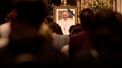 Fedeli assistono a una funzione religiosa in onore di Papa Francesco dopo l'annuncio della sua morte, nella cattedrale di San Giuseppe a Bucarest, Romania, 21 aprile 2025