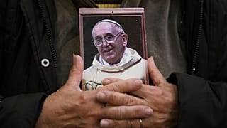 Ein Gläubiger hält ein Porträt des verstorbenen Papstes Franziskus in der Basílica de San José de Flores in Buenos Aires, Argentinien, Montag, 21. April 2025