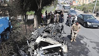 جنود لبنانيون قرب سيارة دمرتها غارة إسرائيلية جنوب صور، أسفرت عن مقتل عنصر من حماس في مارس / آذار 2024.