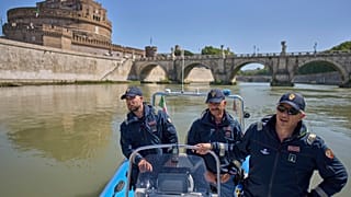 Agenti di polizia pattugliano il Tevere vicino al Vaticano, con Castel Sant'Angelo sullo sfondo, martedì 22 aprile 2025