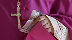 Ein Prälat hält ein Bild von Papst Franziskus, als dieser das Atrium des Petersdoms im Vatikan betritt, Mittwoch, 23. April 2025.